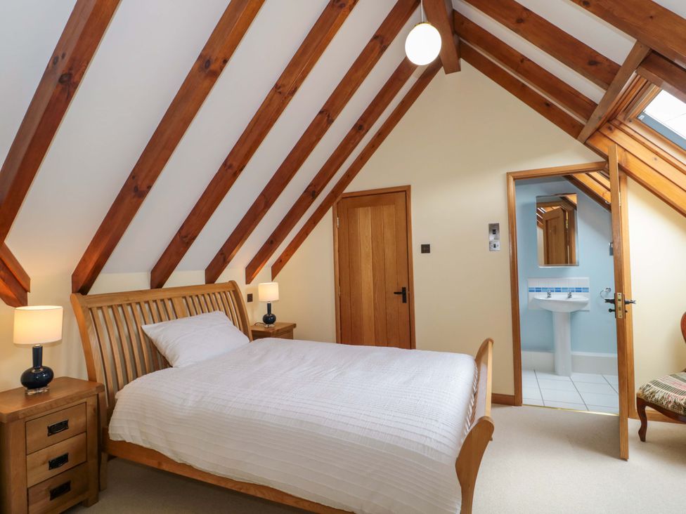A bedroom with a bed and sink at Stowey Mead Stables in Bishop Sutton