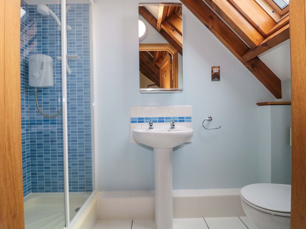 A bathroom with a shower, sink, and toilet at Stowey Mead Stables in Bishop Sutton