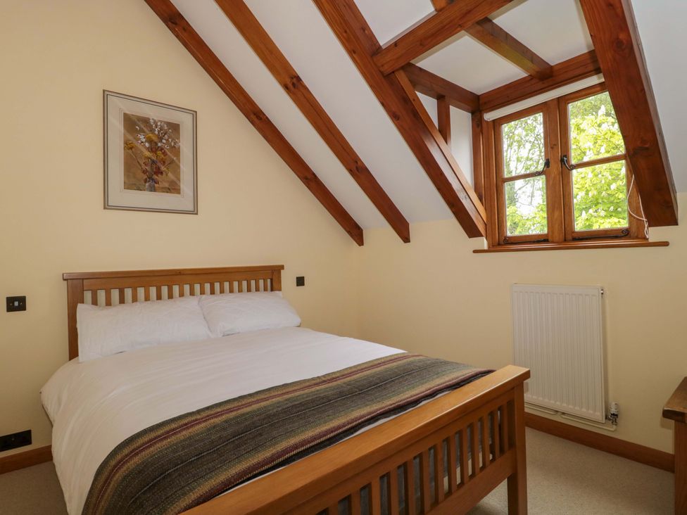 A bedroom with a bed and window at Stowey Mead Stables Bishop Sutton