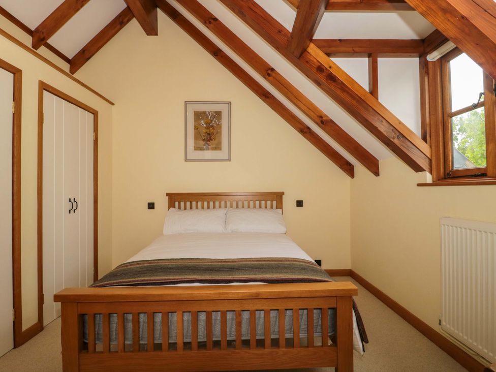 A bedroom with a bed and wardrobe at Stowey Mead Stables Bishop Sutton