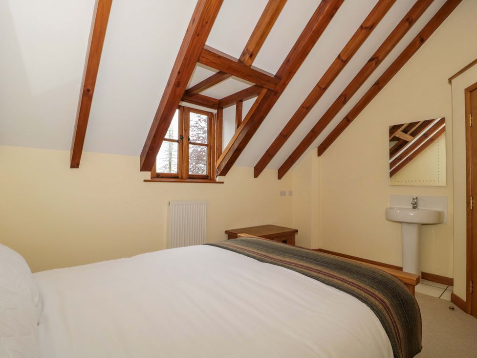 A bedroom with wooden beams and a bed at Stowey Mead Stables in Bishop Sutton