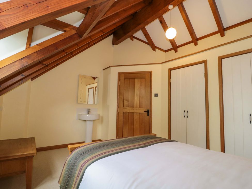A bedroom with a bed and a mirror at Stowey Mead Stables in Bishop Sutton