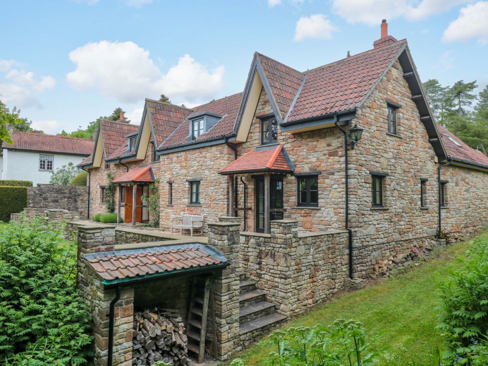 A house with stone walls and a garden at Stowey Mead Stables Bishop Sutton