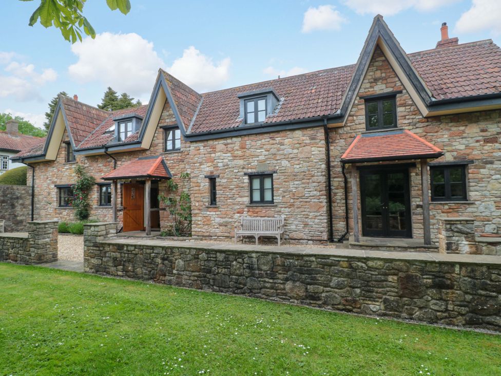 A house with a bench and garden at Stowey Mead Stables Bishop Sutton