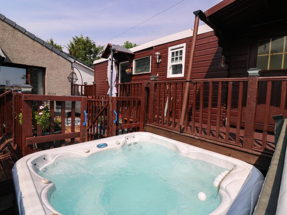 An outdoor area with a hot tub and deck at The Cabin in East Wemyss near Buckhaven