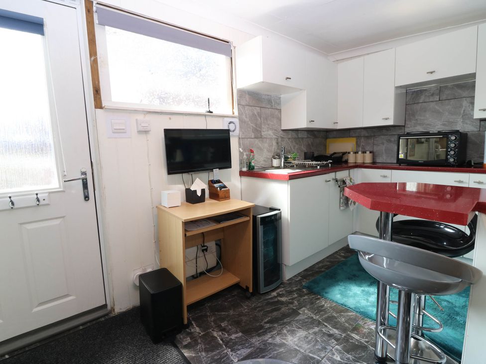 A kitchen with a table and stools at The Cabin East Wemyss near Buckhaven