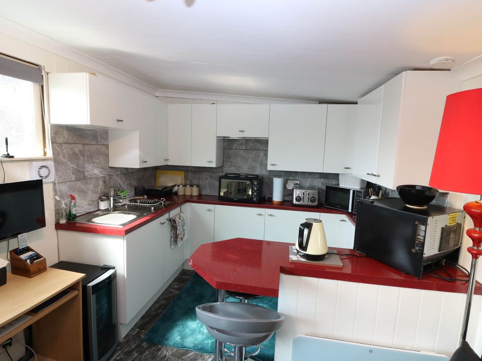 A kitchen with appliances and a sink at The Cabin in East Wemyss near Buckhaven