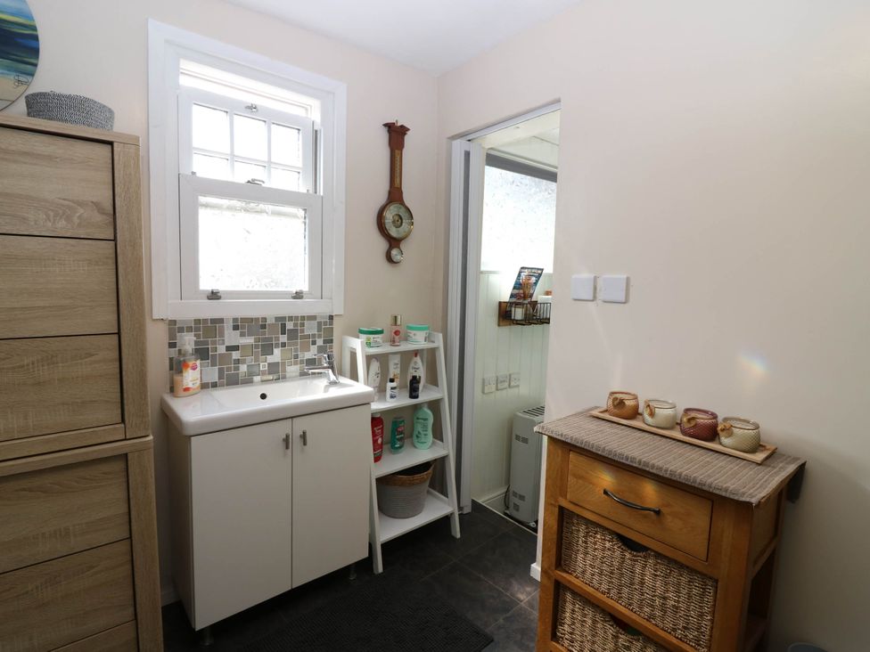 A bathroom with a sink and shelves at The Cabin in East Wemyss near Buckhaven