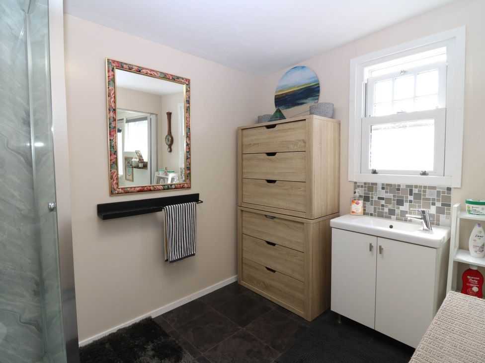 A bathroom with a sink and storage unit at The Cabin in East Wemyss near Buckhaven