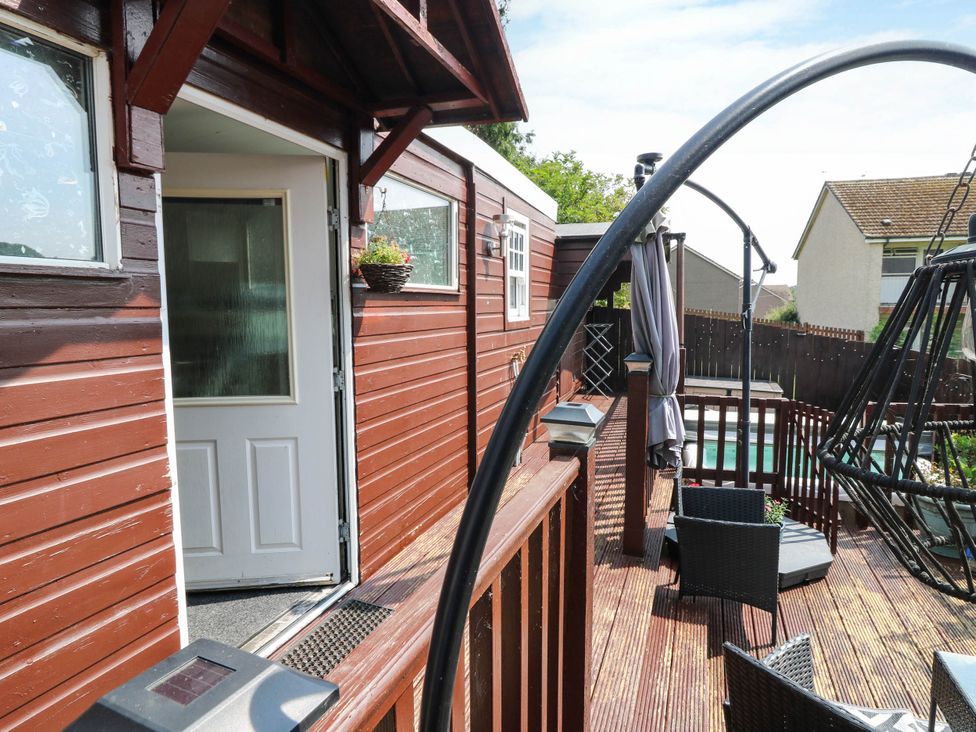 An outdoor deck with a door and swing seat at The Cabin in East Wemyss near Buckhaven