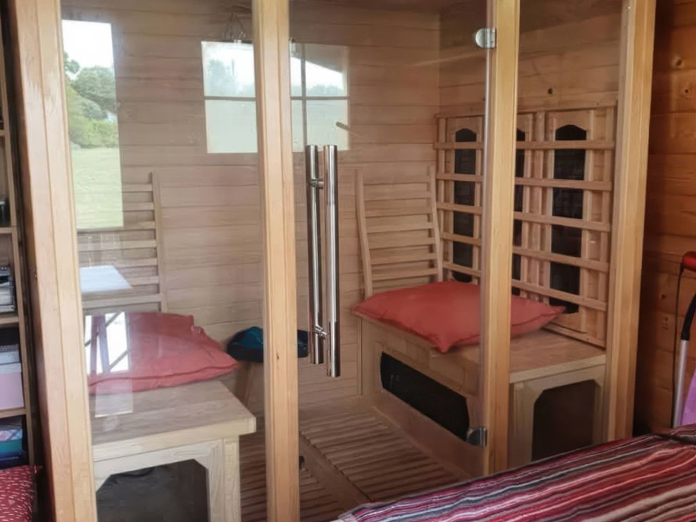 A sauna with wooden benches and pillows at The Cabin in East Wemyss near Buckhaven