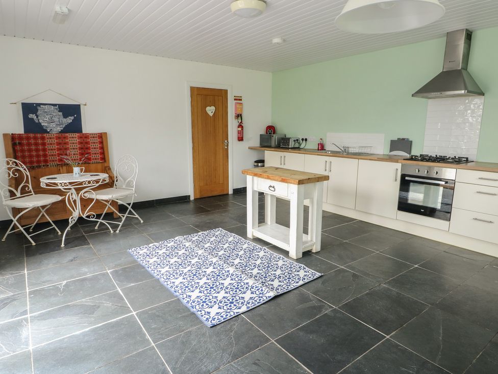 A kitchen with a dining area and cooking facilities at Seiriol Shepherds hut Ty Croes
