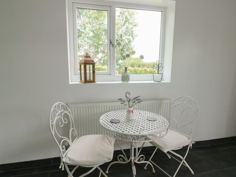 A dining area with a table and chairs at Seiriol Shepherds hut in Ty Croes