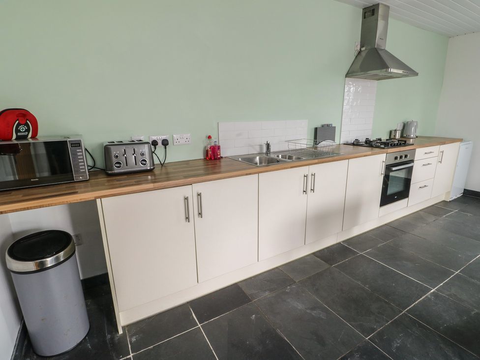 A kitchen with appliances and workspace at Seiriol Shepherds hut, Ty Croes