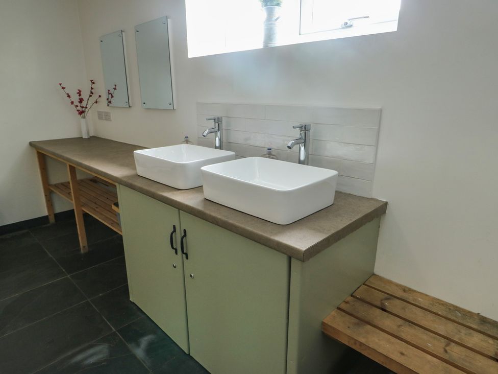 A bathroom with sinks and mirrors at Seiriol Shepherds hut Ty Croes