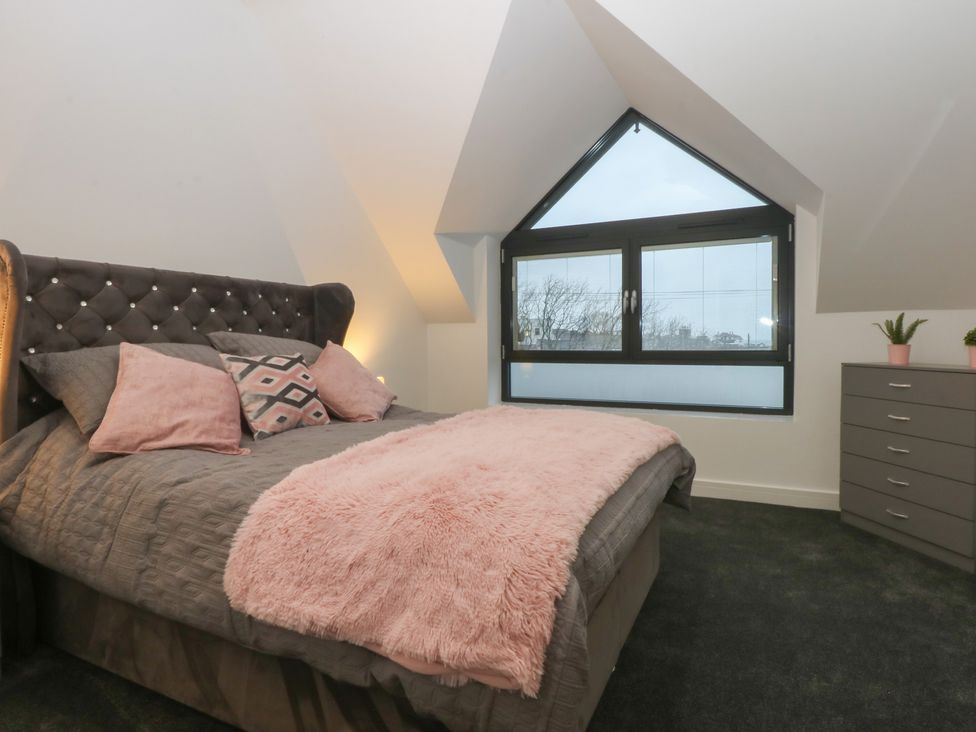 A bedroom with a bed and a dresser at 2 Harbour Lights Cemaes Bay