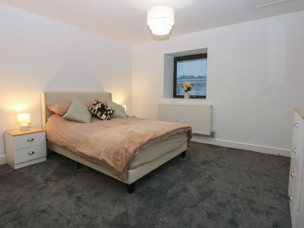 A bedroom with a bed and bedside tables at 2 Harbour Lights in Cemaes Bay