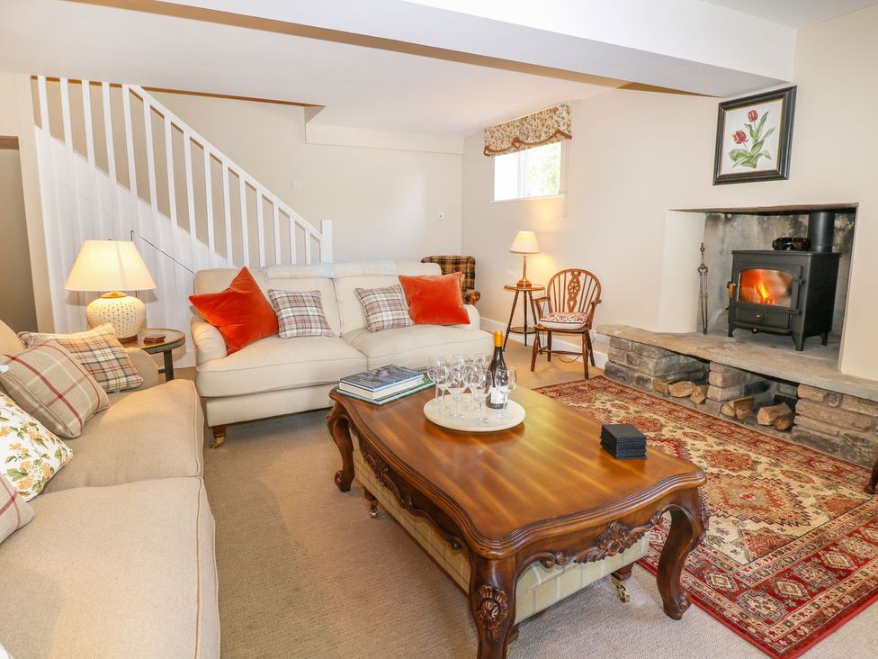 A living room with a fireplace and sofa at The Bothy in Wildboarclough