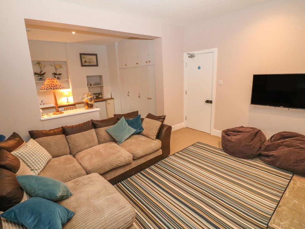 A living room with a sofa and TV at The Bothy in Wildboarclough