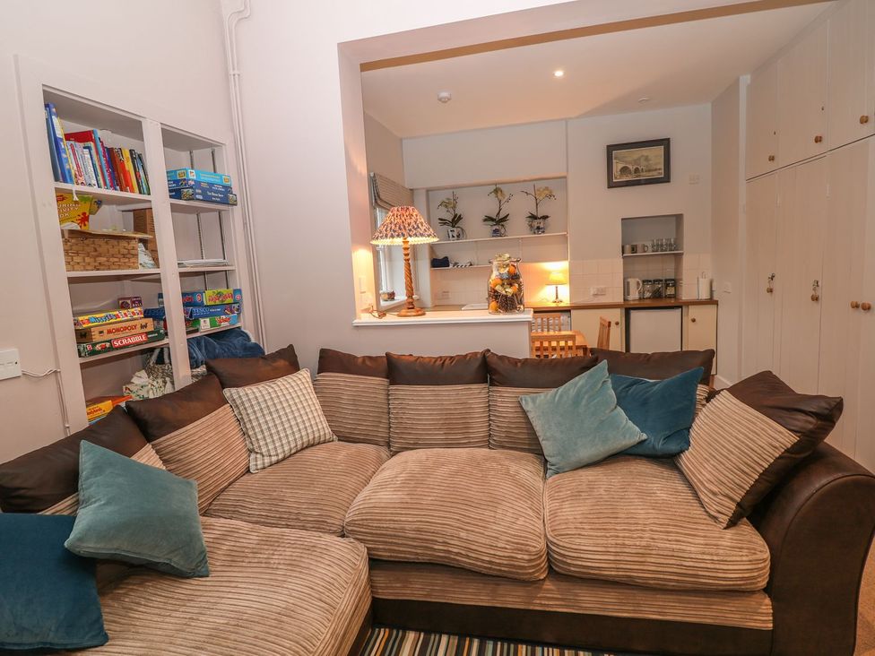 A living room with a sofa and bookshelf at The Bothy in Wildboarclough