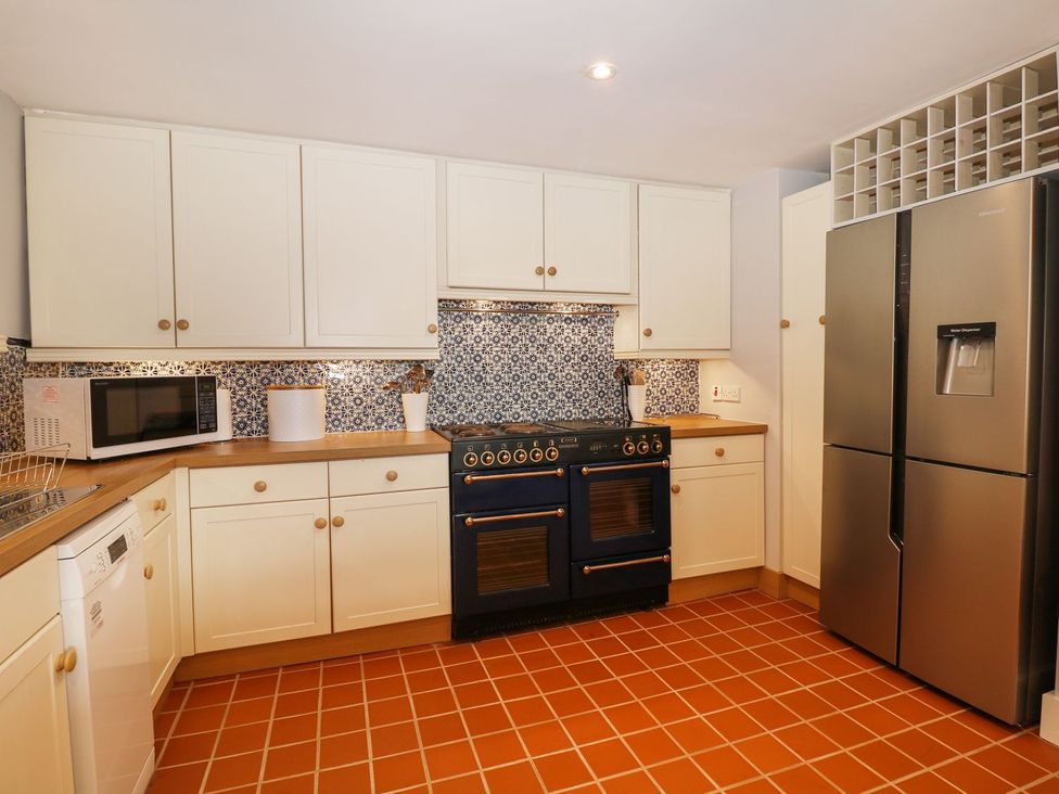 A kitchen with a stove and refrigerator at The Bothy in Wildboarclough