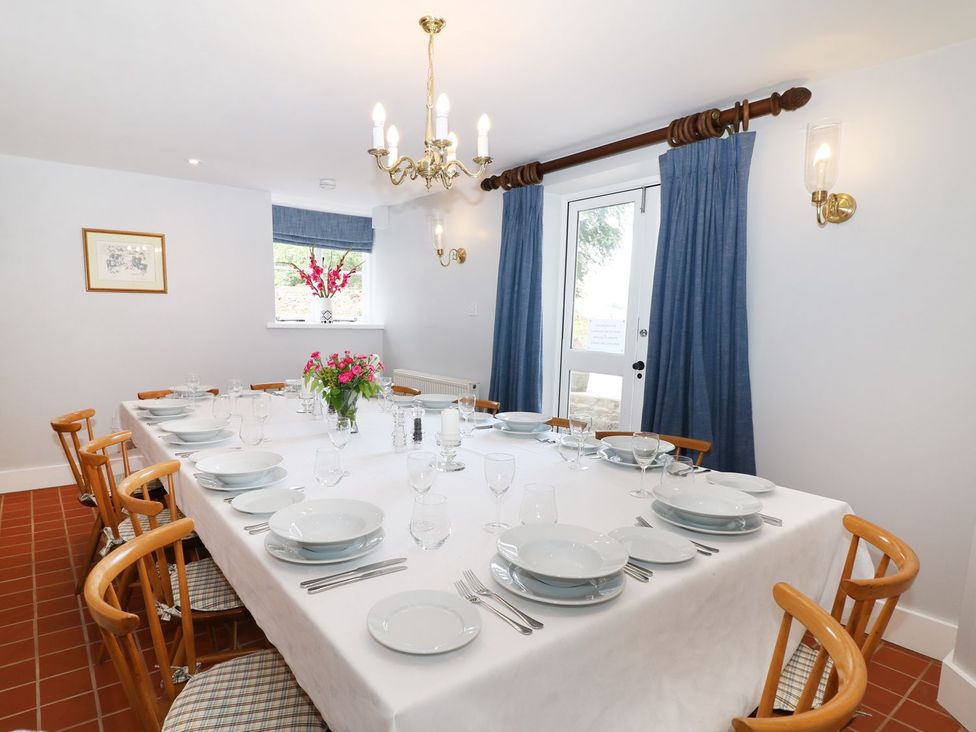 A dining room with a large table set for a meal at The Bothy in Wildboarclough