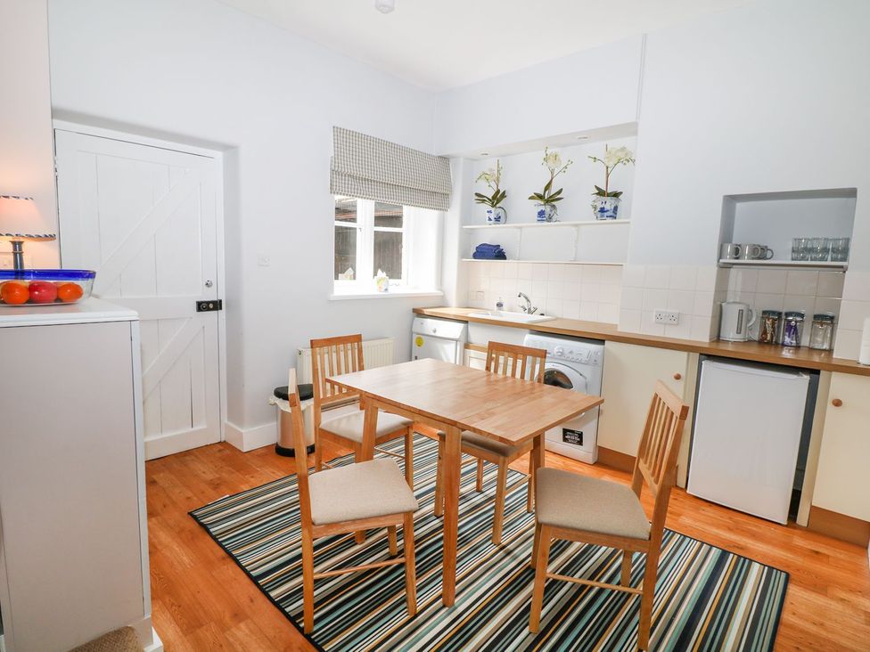 A kitchen with a table and chairs at The Bothy in Wildboarclough