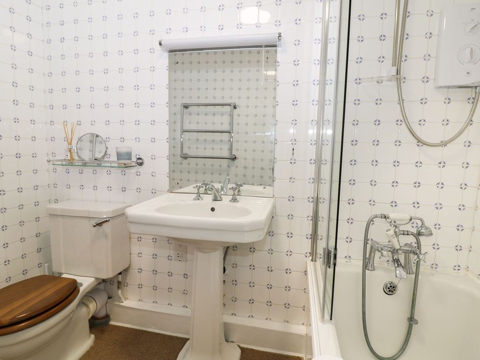 A bathroom with a sink, toilet, shower, and bathtub at The Bothy in Wildboarclough