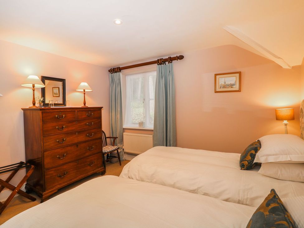 A bedroom with two beds and a dresser at The Bothy in Wildboarclough