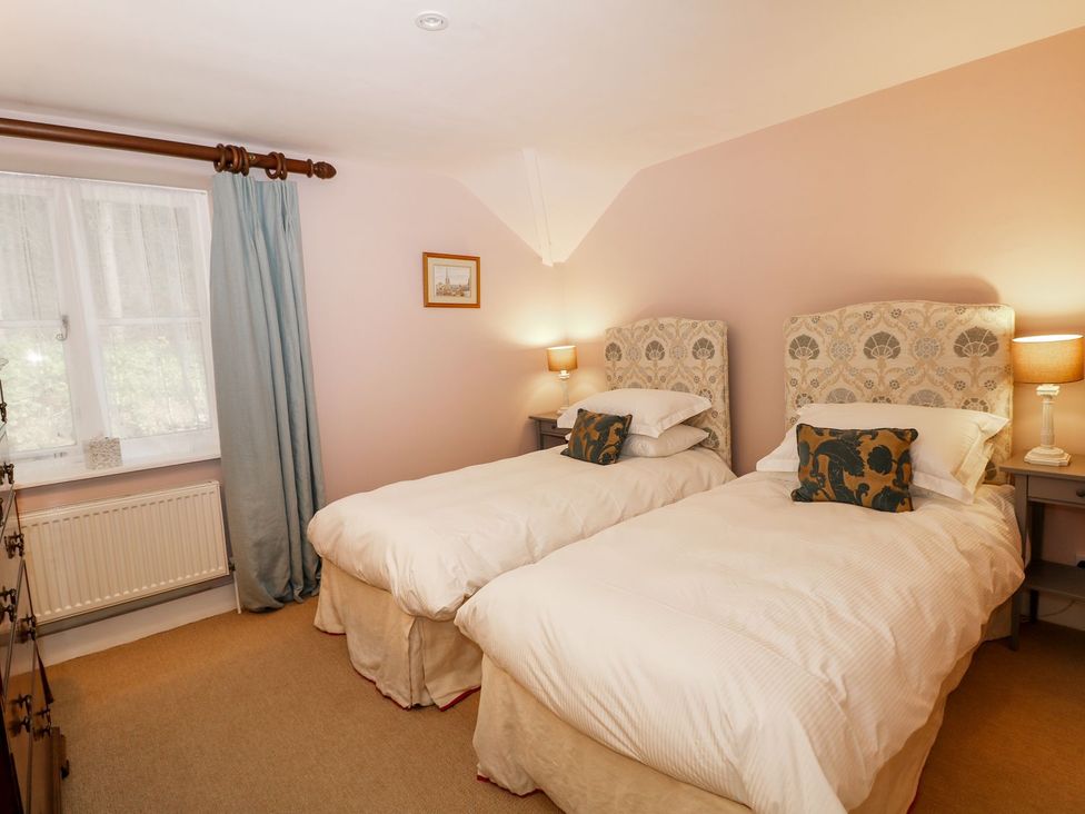 A bedroom with two single beds and a window at The Bothy in Wildboarclough
