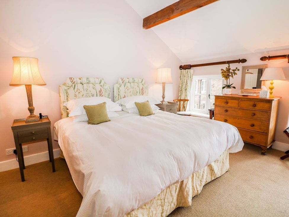 A bedroom with a double bed and furniture at The Bothy in Wildboarclough