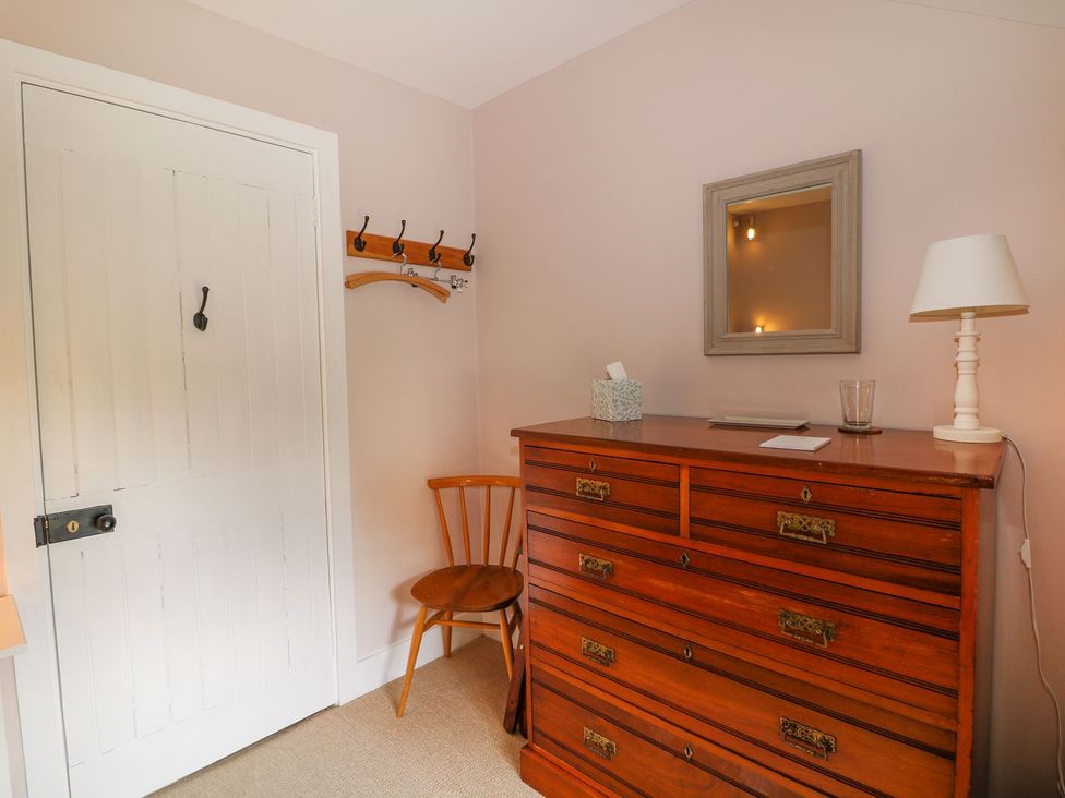 A bedroom with a mirror and chest of drawers at The Bothy in Wildboarclough