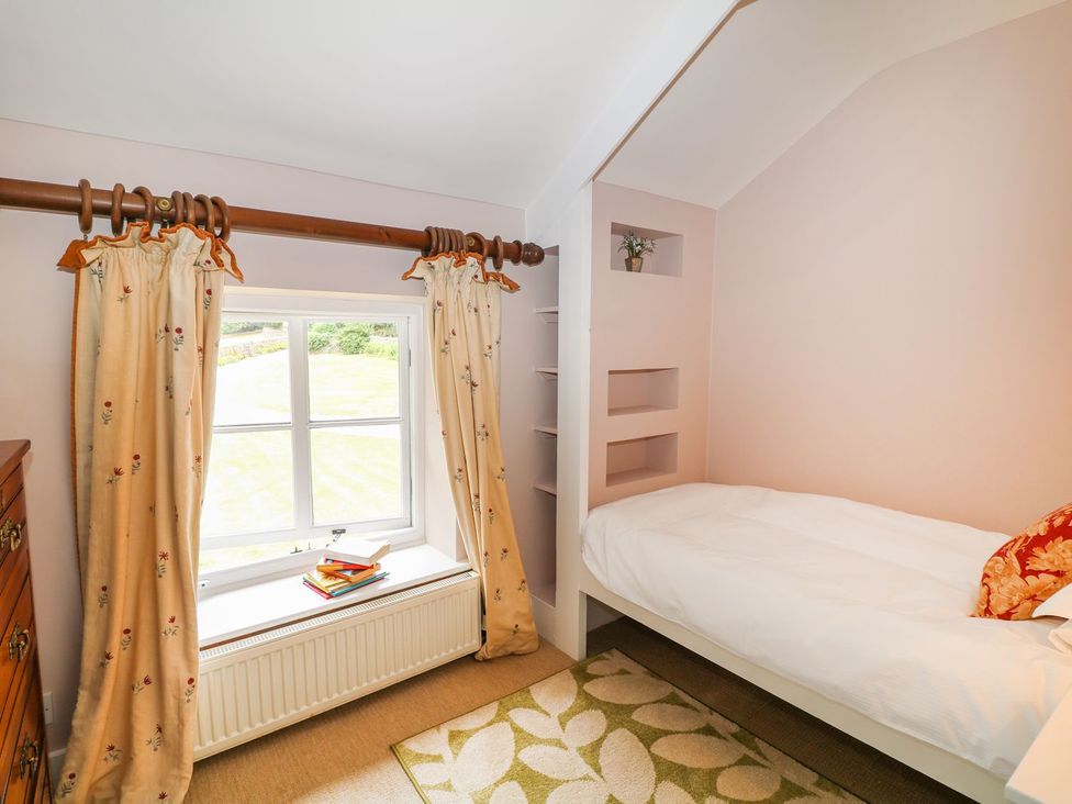 A bedroom with a bed and window at The Bothy in Wildboarclough