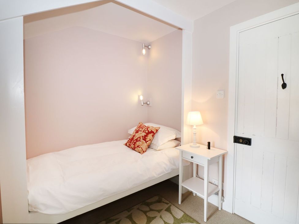 A bedroom with a bed and bedside table at The Bothy in Wildboarclough