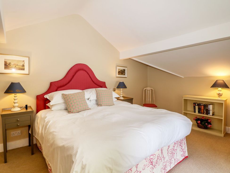 A bedroom with a double bed and a bookshelf at The Bothy in Wildboarclough
