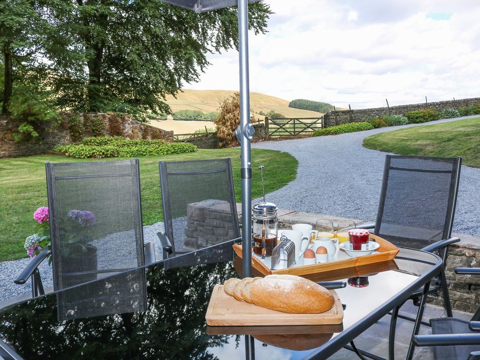 An outdoor dining area with a table set for breakfast at The Bothy in Wildboarclough