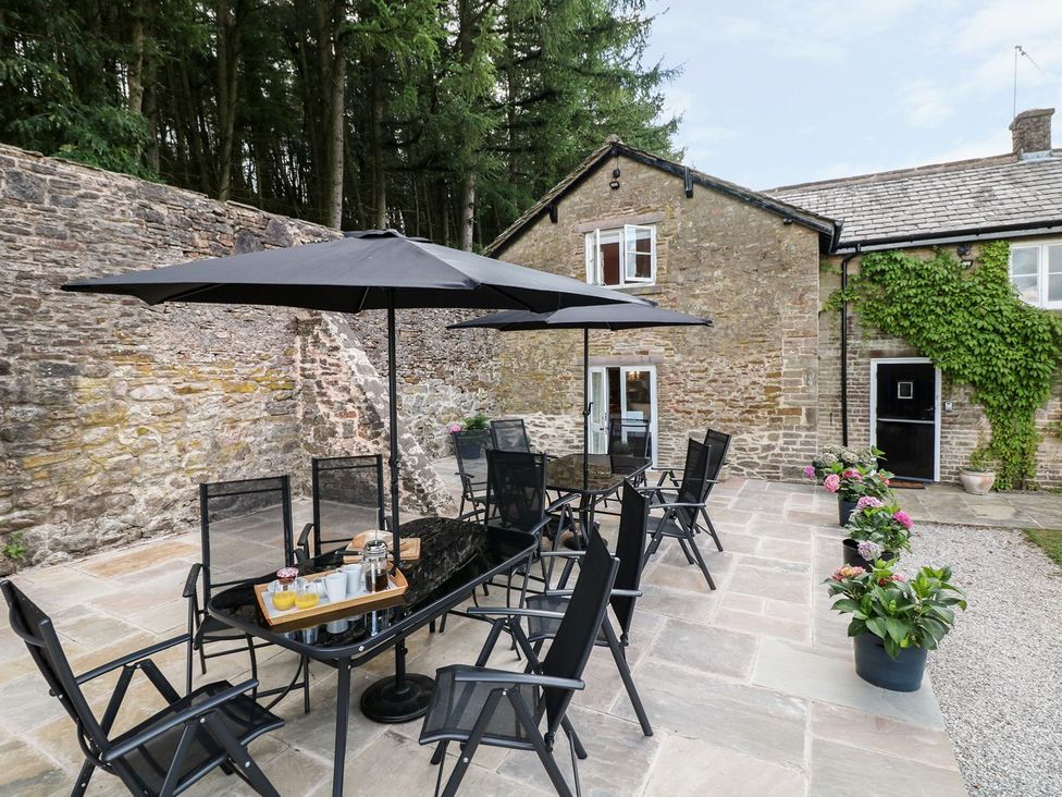 An outdoor dining area with furniture and flower pots at The Bothy in Wildboarclough