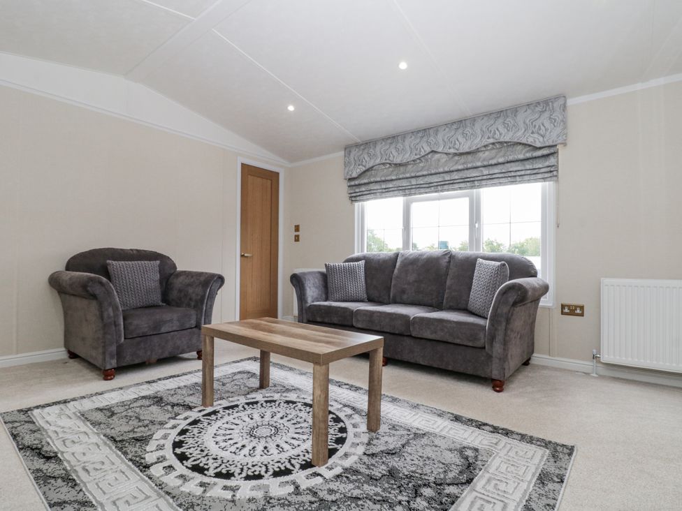 A living room with a sofa and armchair in The Cabin Thornton Dale