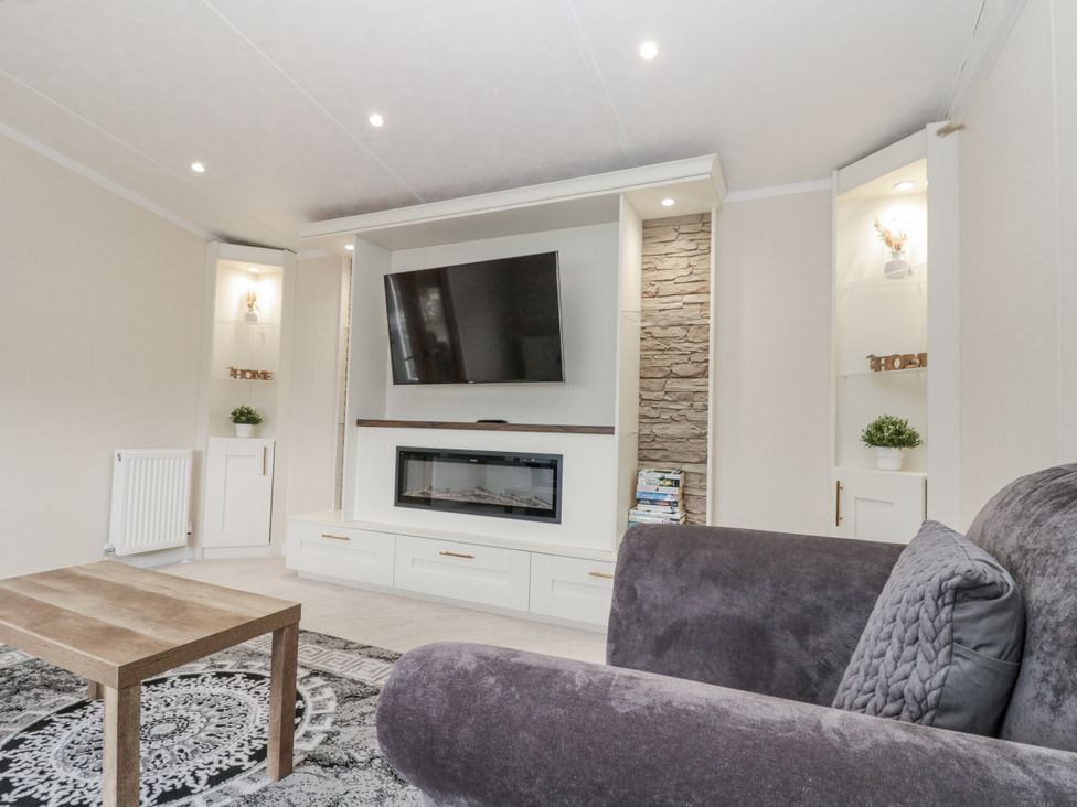 A living room with a television and fireplace cabinet at The Cabin Thornton Dale