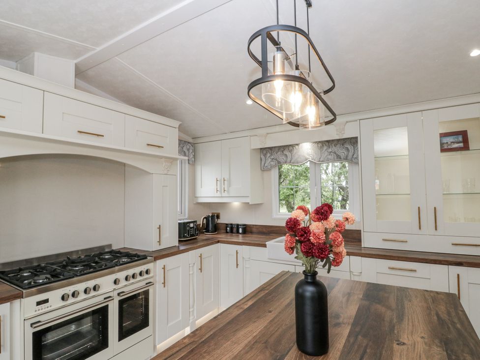 A kitchen with a countertop, oven, and storage cabinets at The Cabin in Thornton Dale