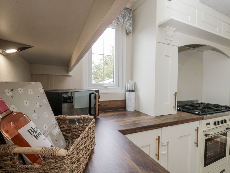 A kitchen with an oven, microwave, and countertop at The Cabin in Thornton Dale