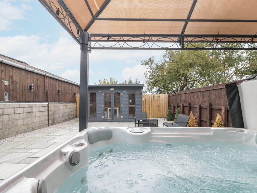 A hot tub and shed in an outdoor area at The Cabin in Thornton Dale