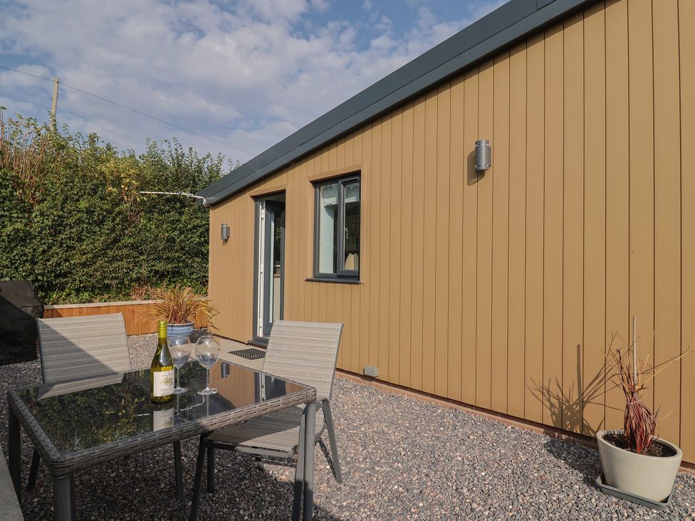 An outdoor seating area with a table and chairs at The Roost in Whitford Nr. Colyton