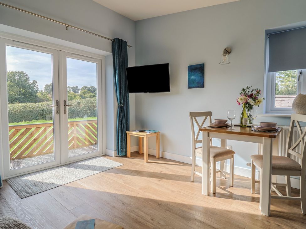 A dining area with a table and chairs at The Roost in Whitford Nr. Colyton