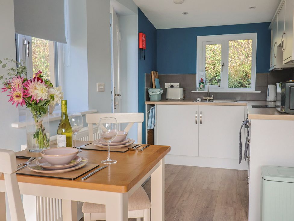 A kitchen with a dining table set at The Roost in Whitford Nr. Colyton