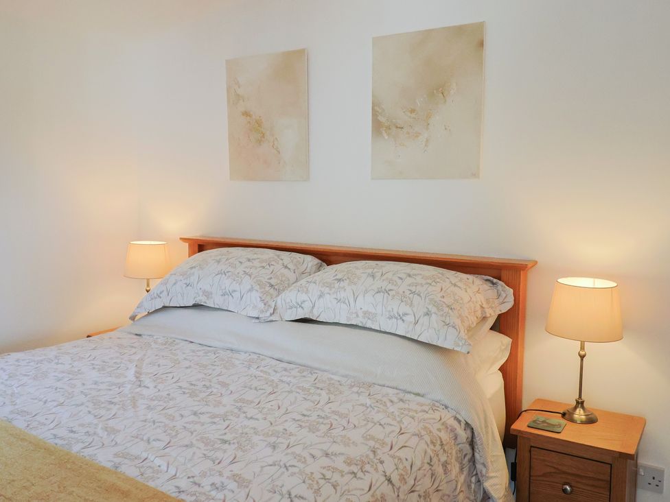A bedroom with a bed and bedside lamps at The Roost in Whitford Nr. Colyton