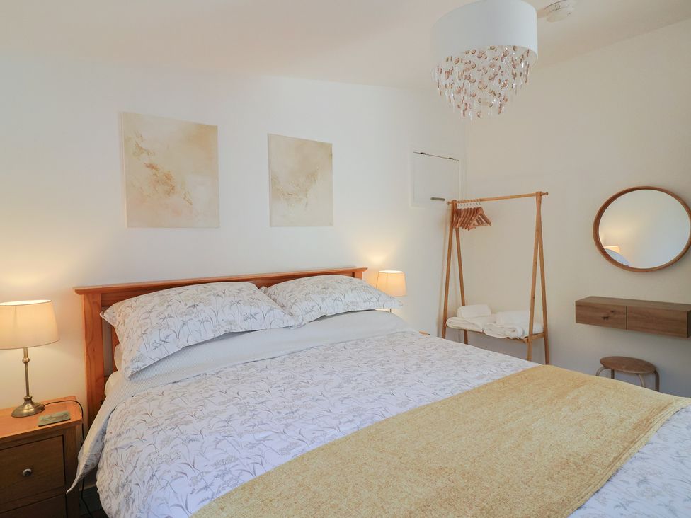 A bedroom with a bed and bedside lamp at The Roost in Whitford Nr. Colyton