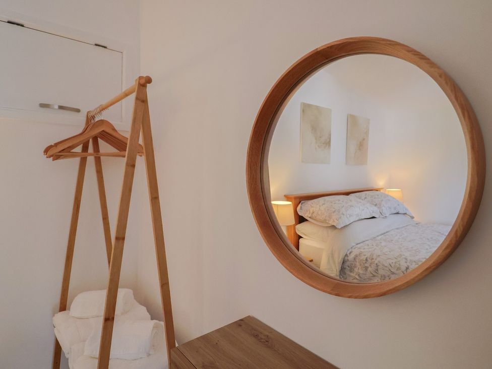 A bedroom with a bed and a clothing rack at The Roost Whitford Nr. Colyton