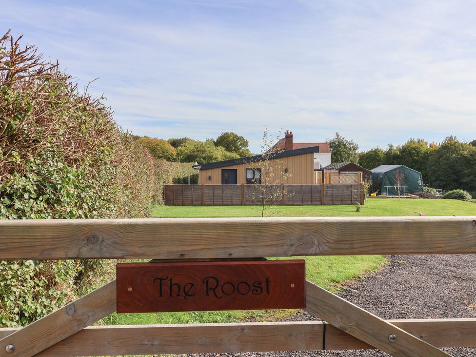 An outdoor area with a gate and house view at The Roost Whitford Nr. Colyton
