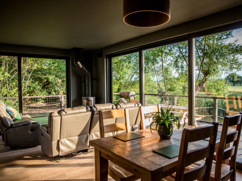 A living room with a sofa and dining table at The Red House in Farndon